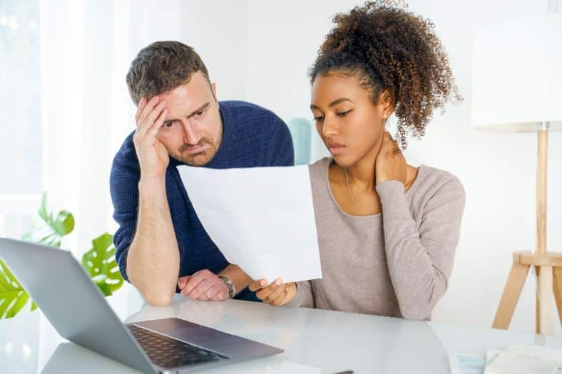 a man and women looking at bills debating on bankruptcy.