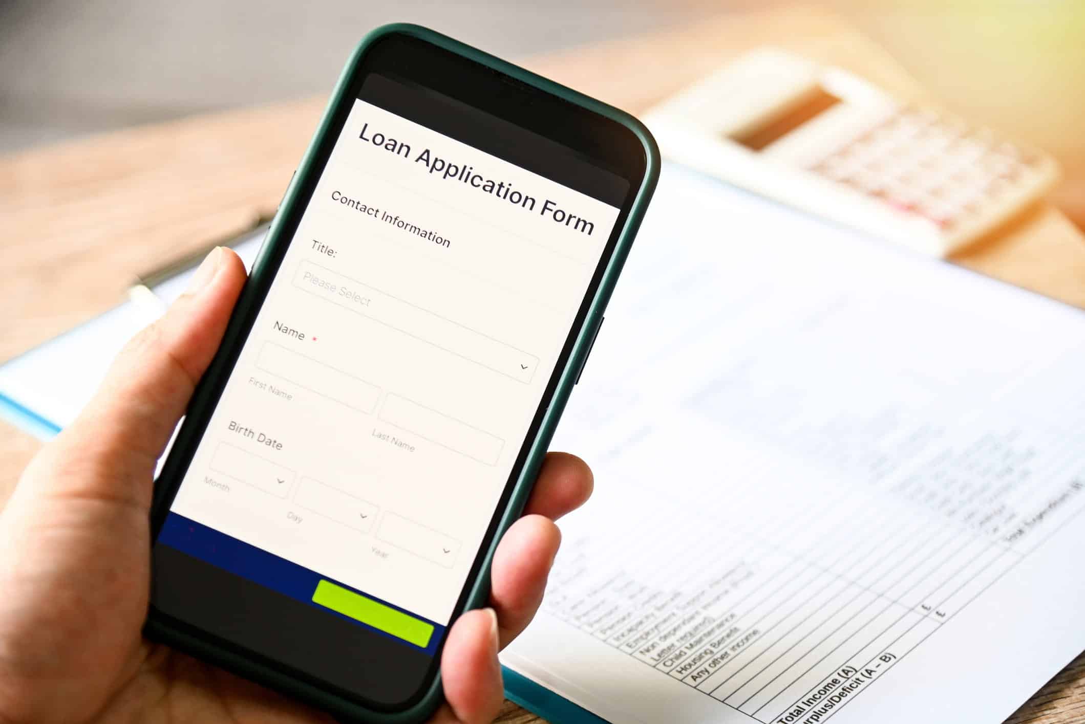 person holding a phone with an open student loan application