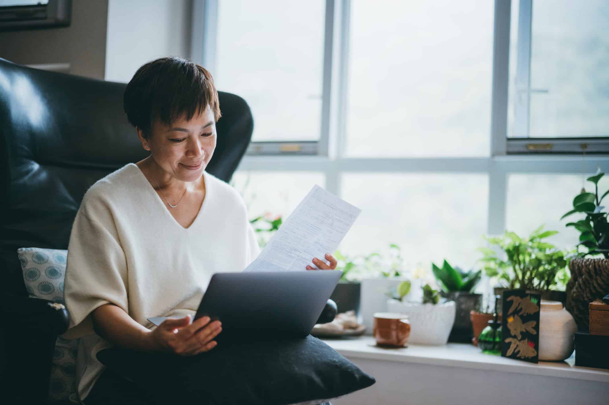 elderly woman calculating expenses in front of the computer