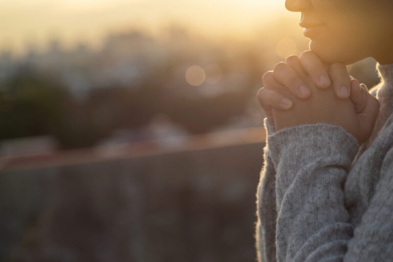 hopeful woman with hands crossed under her chin.