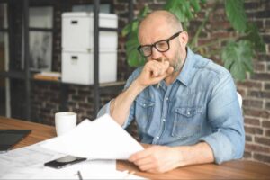 worried man looking at bankruptcy documents