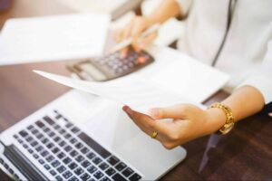 woman looking at a document making calculations no a calculator