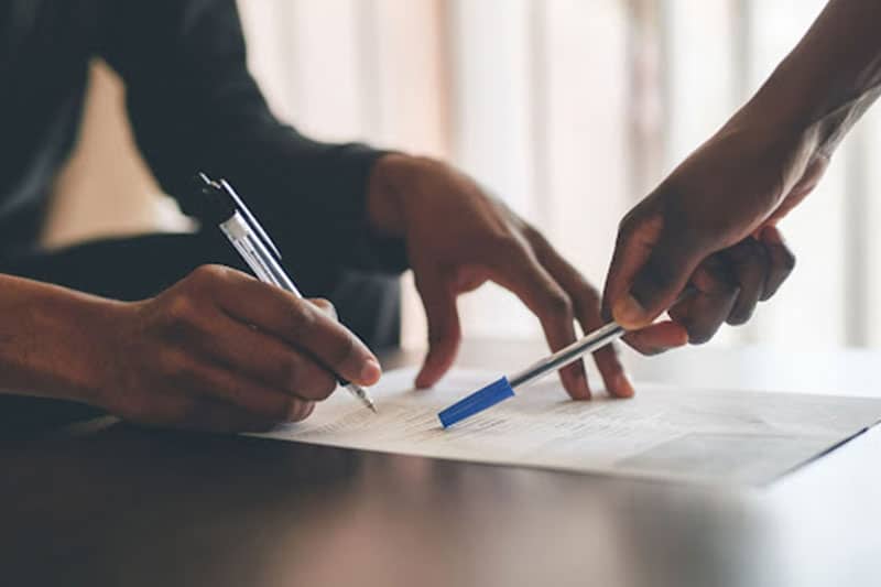 Two people talking over paperwork