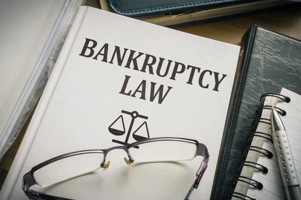 bankruptcy law textbook with glasses on top of it