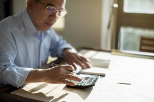 man making financial calculations with calculator