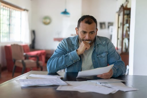 stressed man looking at bankruptcy paperwork