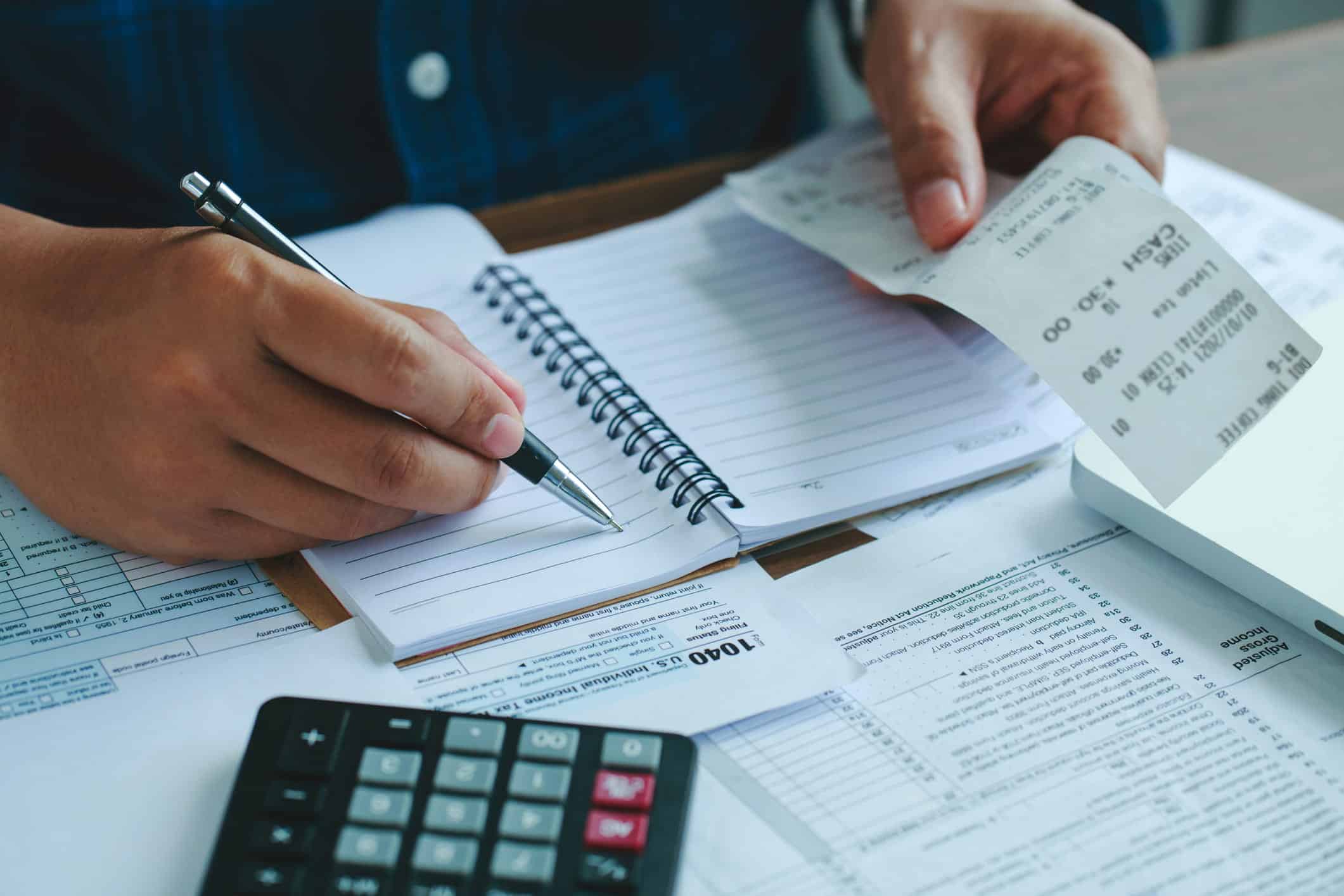 Man calculating domestic bills on wooden desk