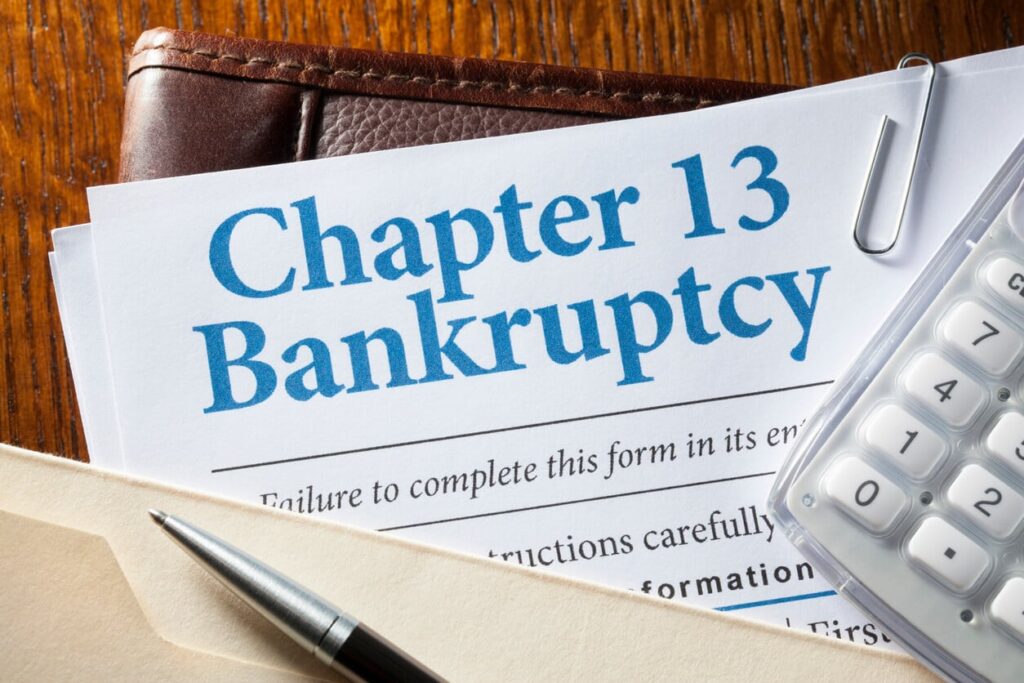 Chapter 13 bankruptcy paperwork with calculator and pen