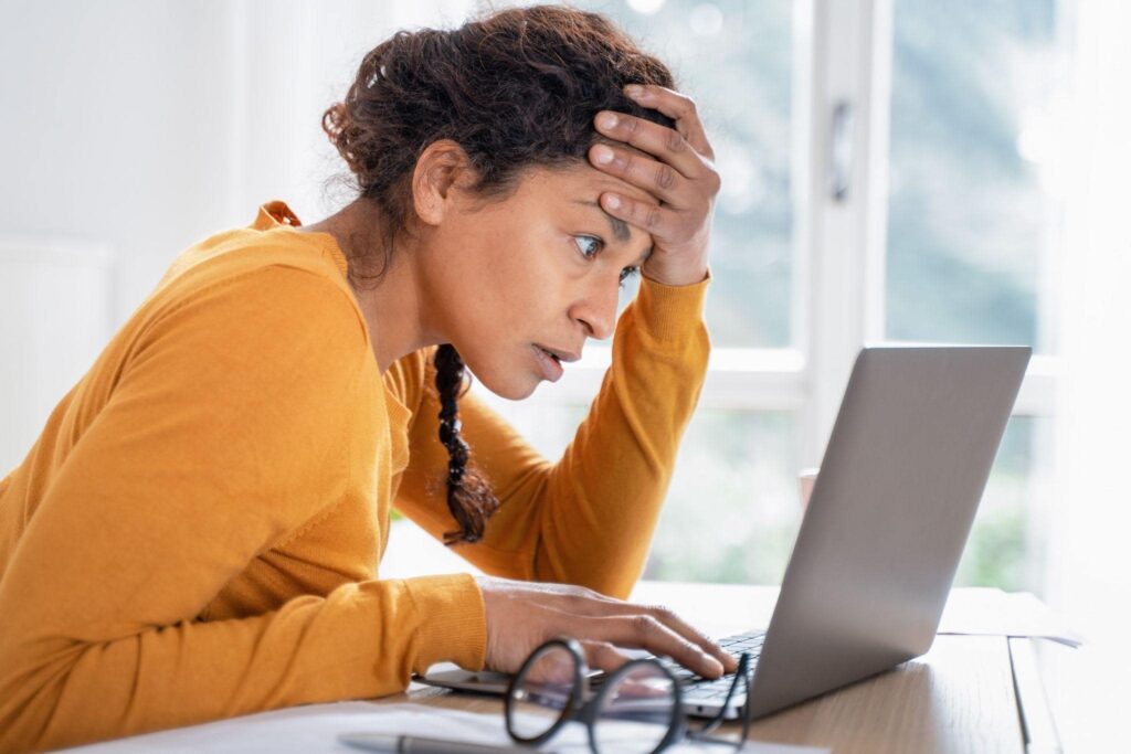 woman looking at computer feeling stressed about bills considering filing bankruptcy