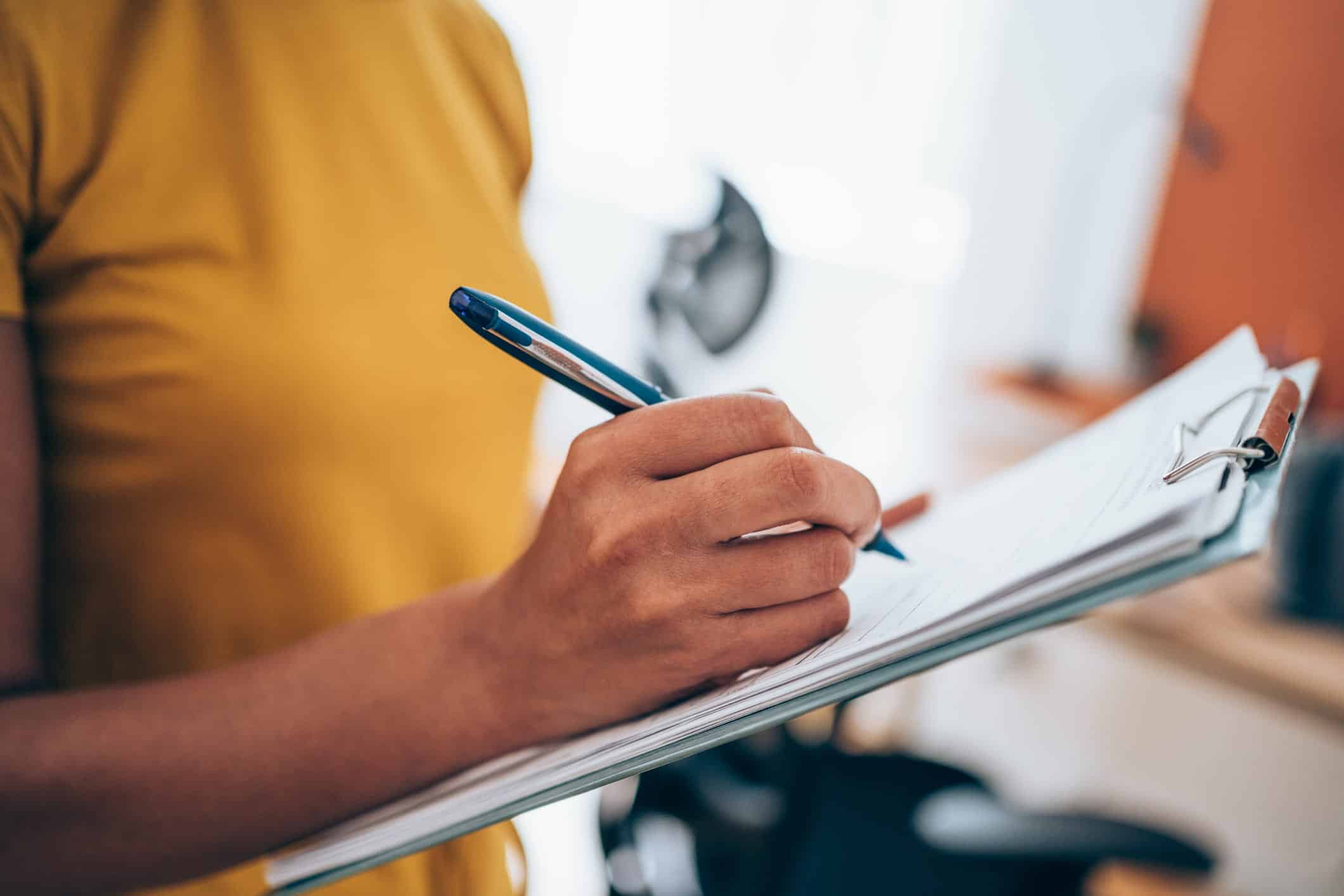 woman filling out bankruptcy documents with a pen