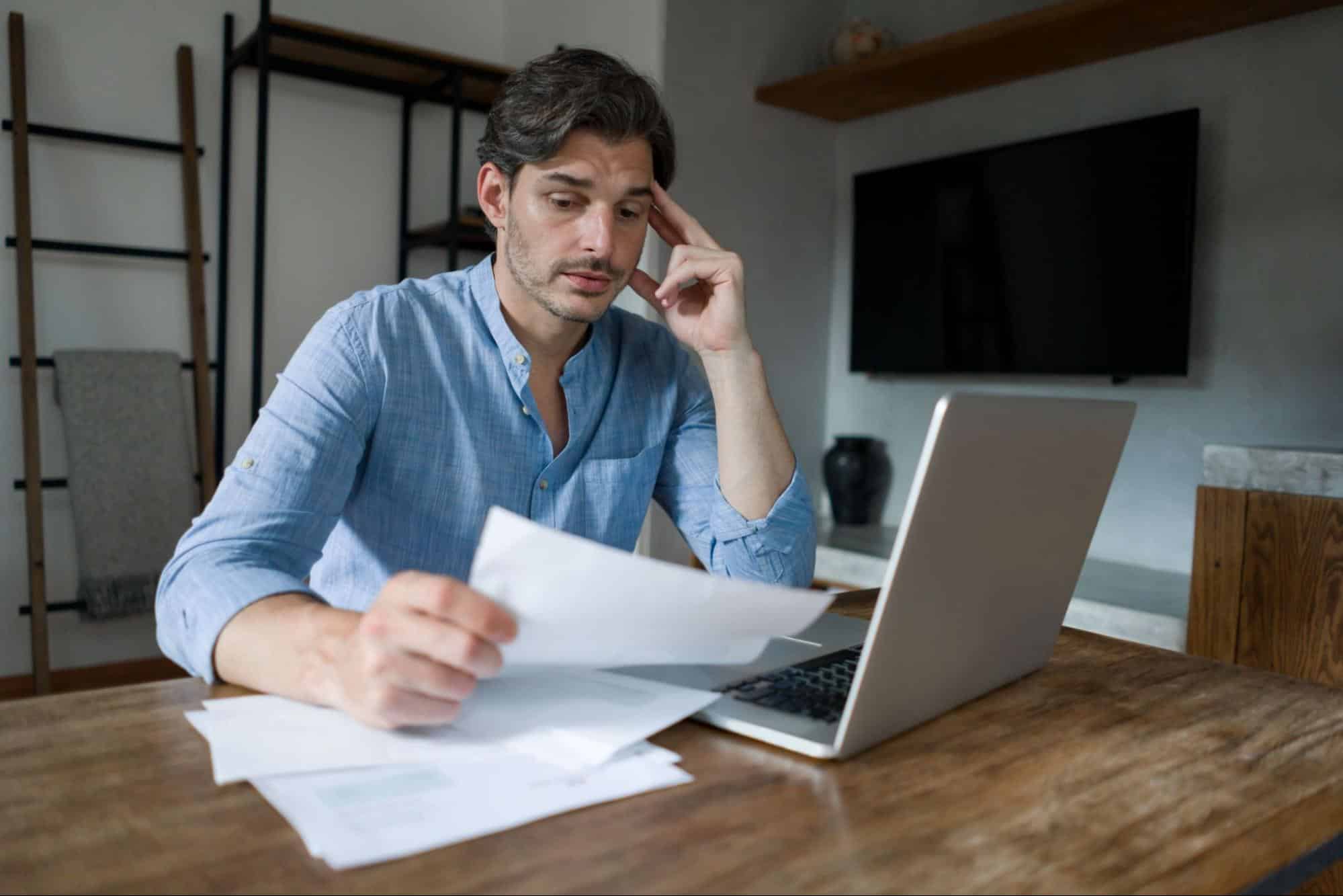 man looking over bills debating if he should file bankruptcy