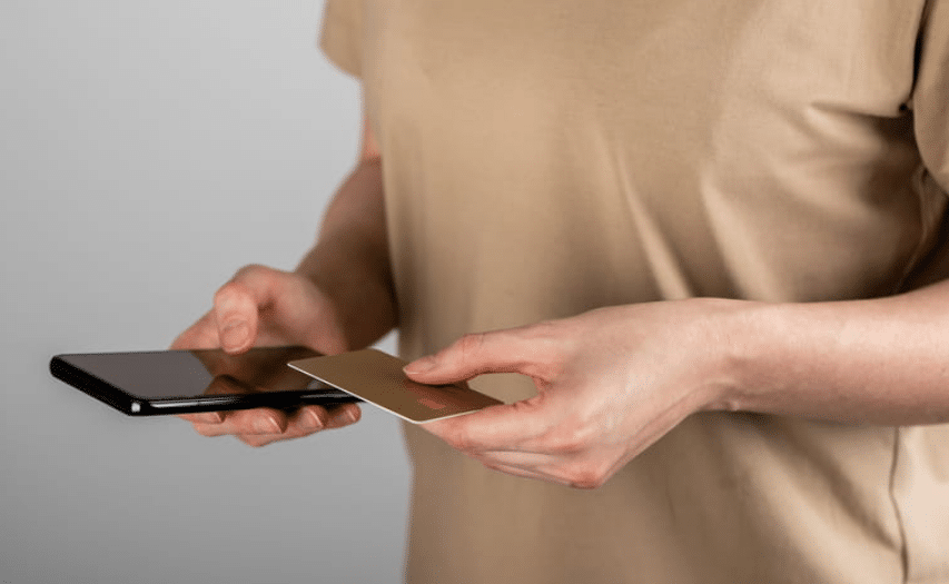 Closeup of a person holding a credit card and a smartphone