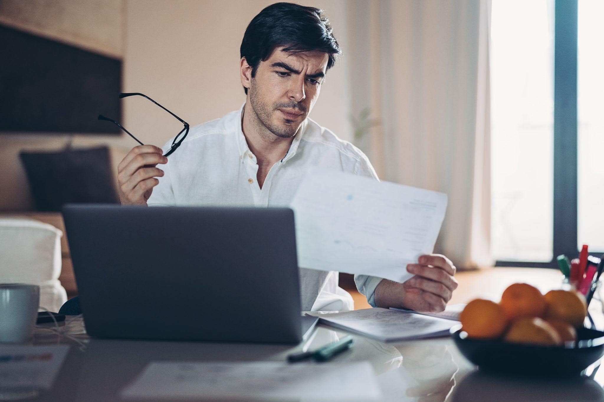 man looking discouraged looking at bills