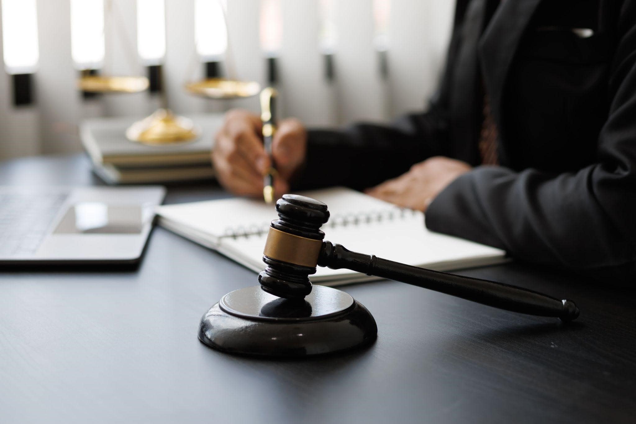 Lawyer working on paperwork with a gavel next to him