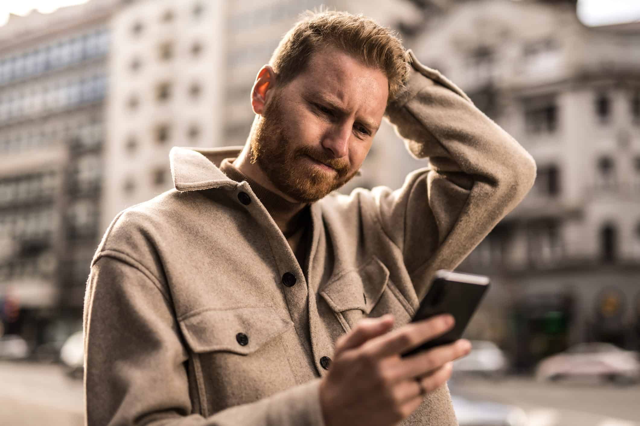 stressed man looking at his phone