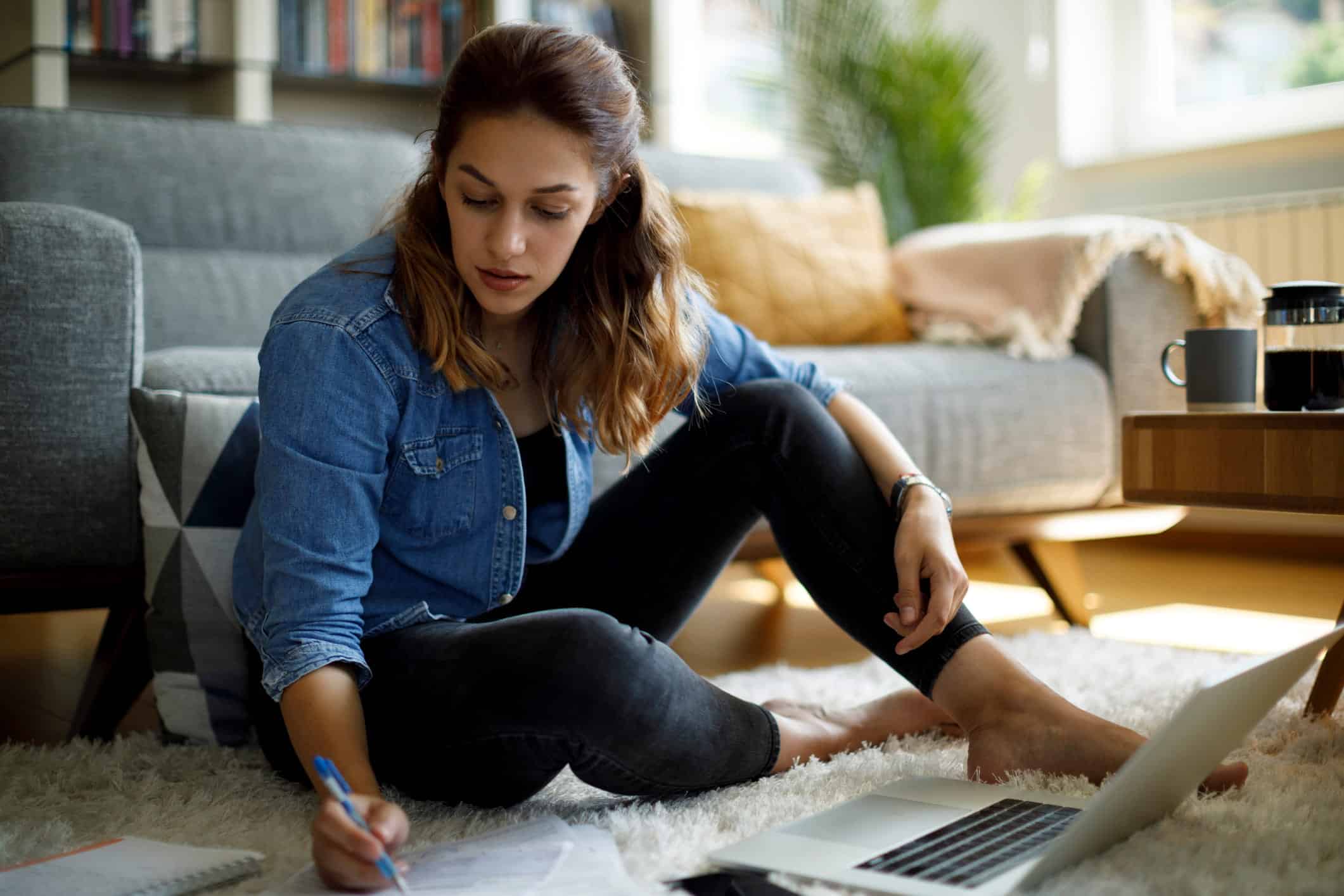 woman with student loan debt filling out bankruptcy paperwork with her laptop open