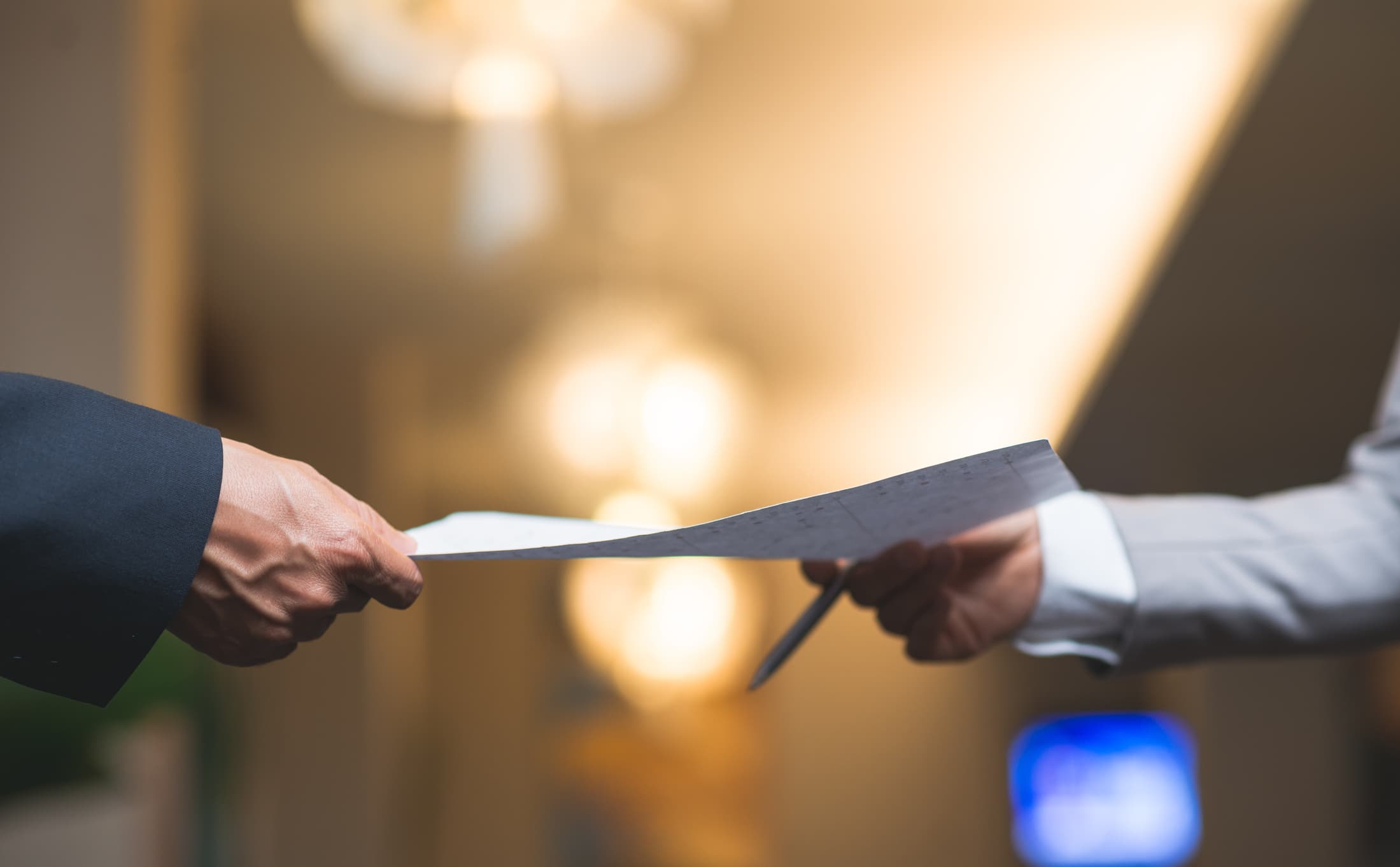 person handing paperwork to another person