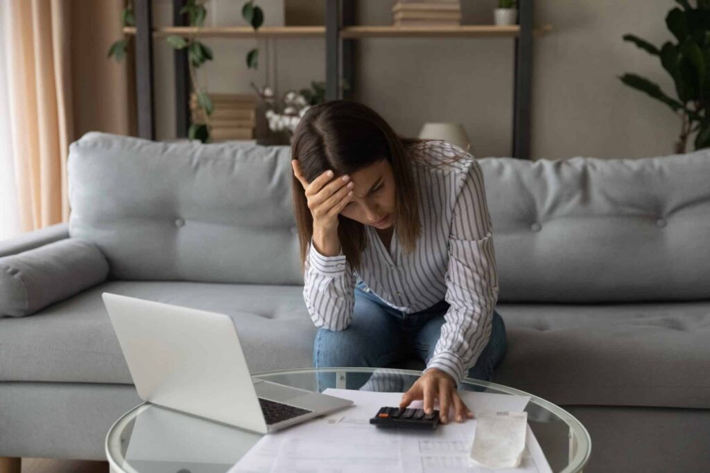 stressed out woman making calculations on calculator