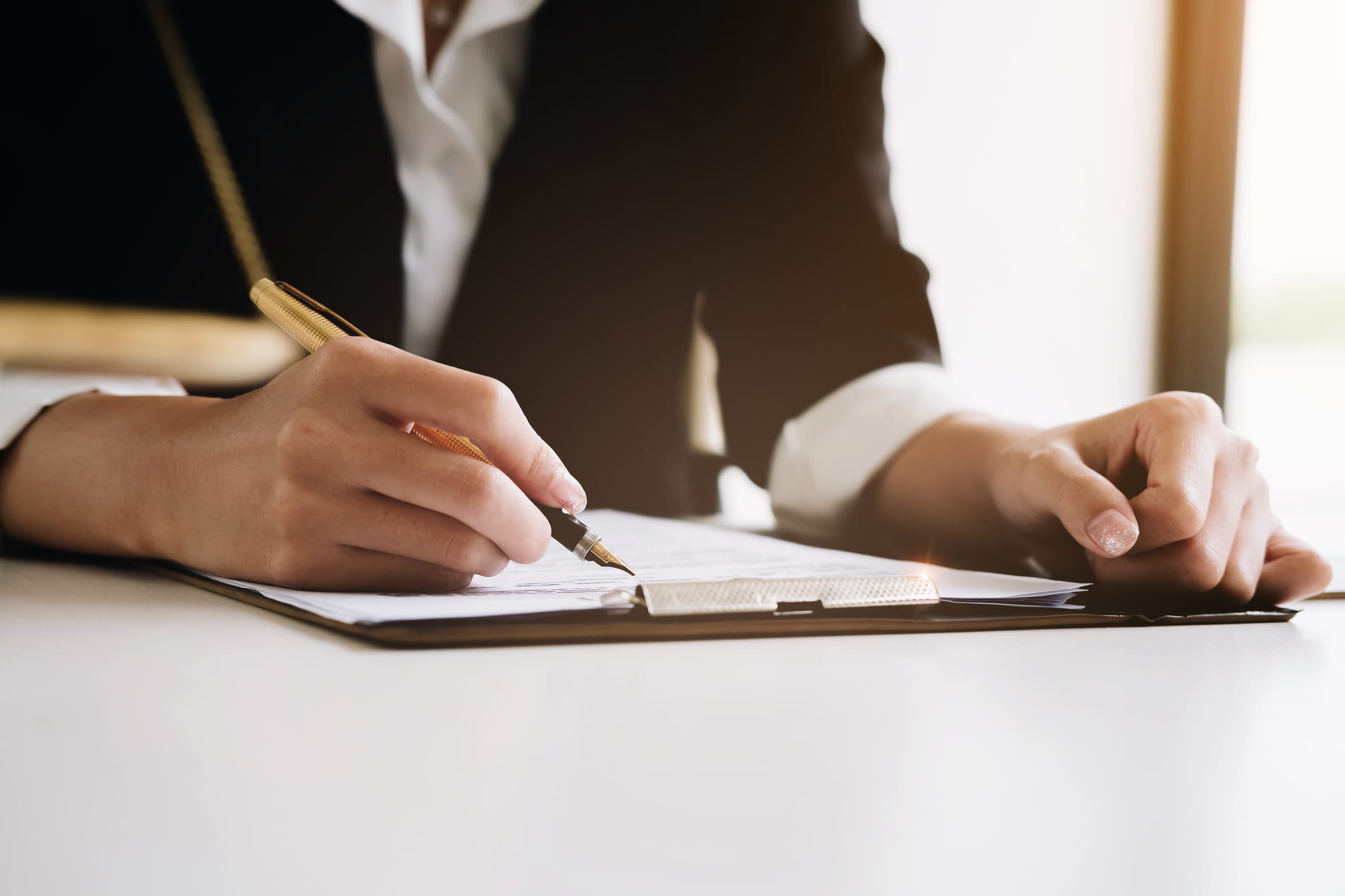 person writing on document with pen