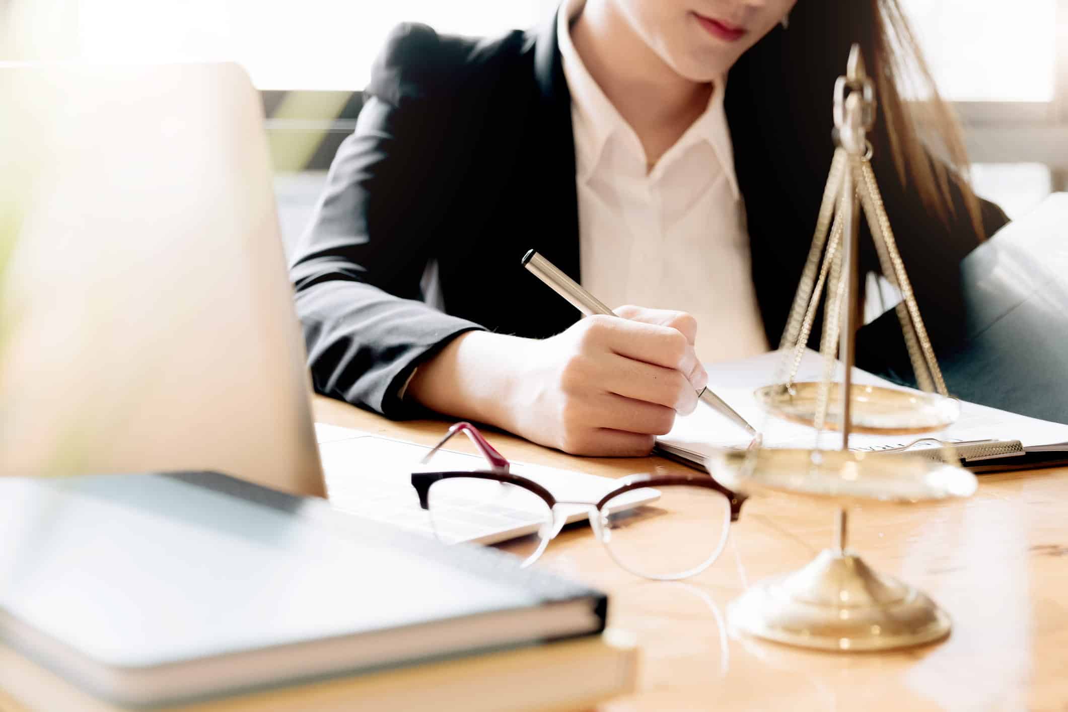 bankruptcy attorney sitting on a desk and writing something on a document