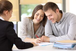 happy couple signing documents together