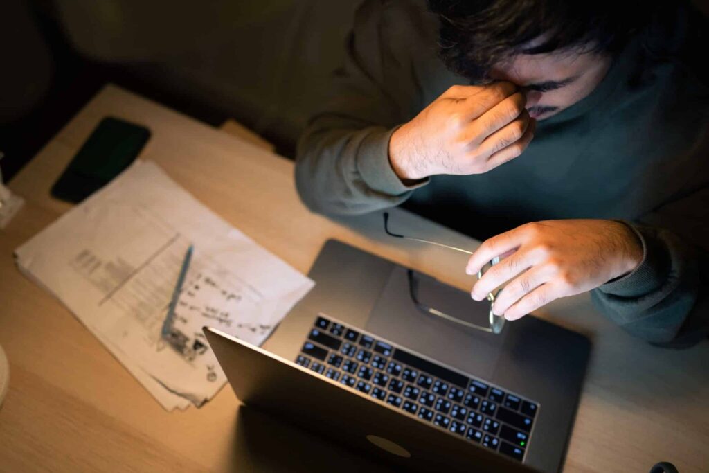 worried man assessing his financial situation on laptop