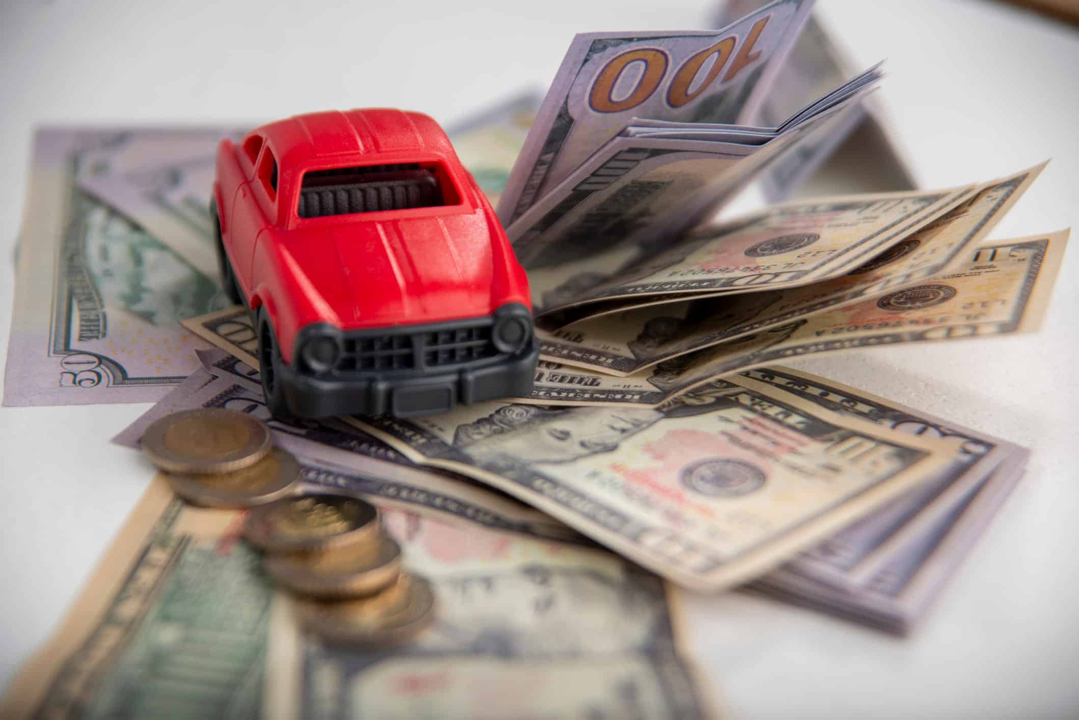 car on top of cash and coins