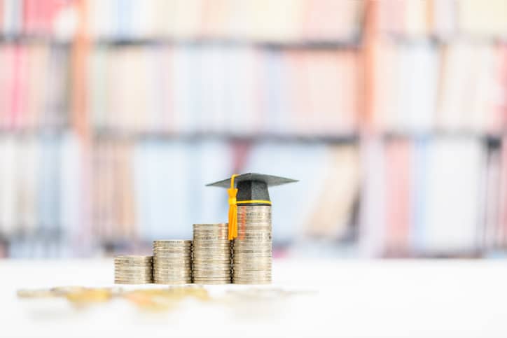 a stack of coins with a graduation cap