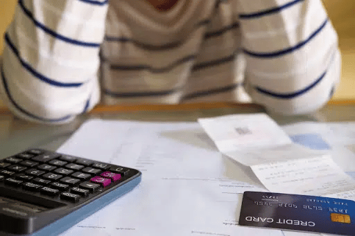 devastated person with credit card and calculator