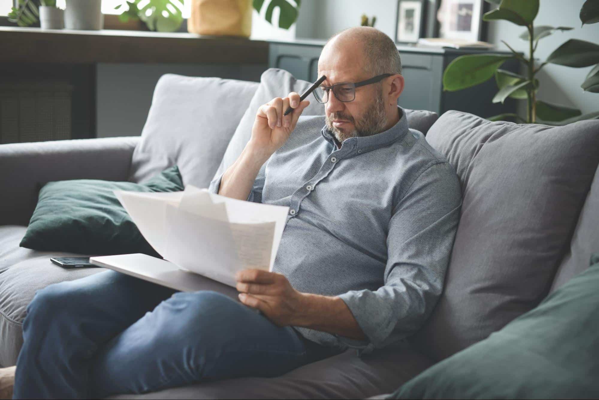 stressed man looking at bankruptcy papers