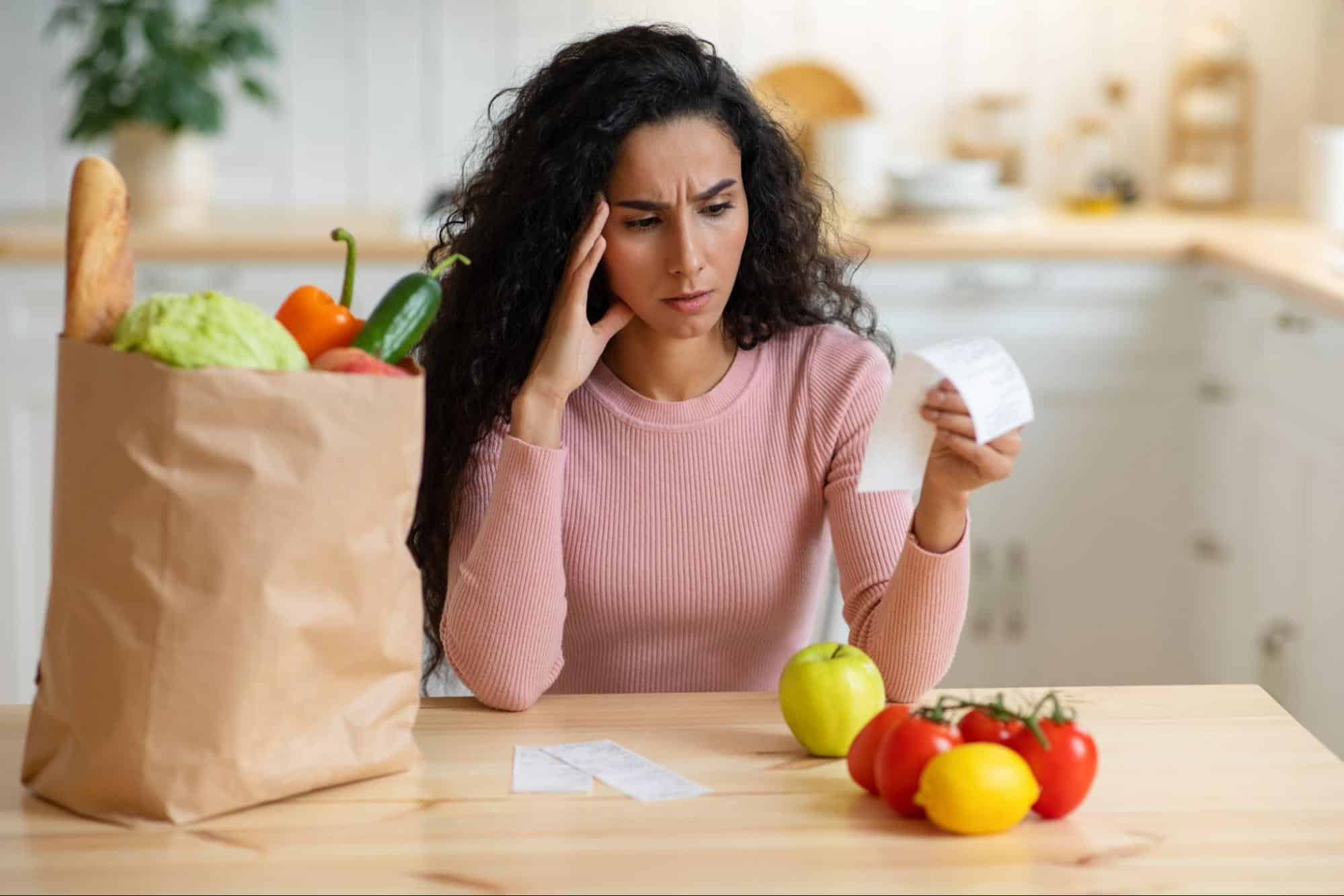 woman looking at expensive grocery bill