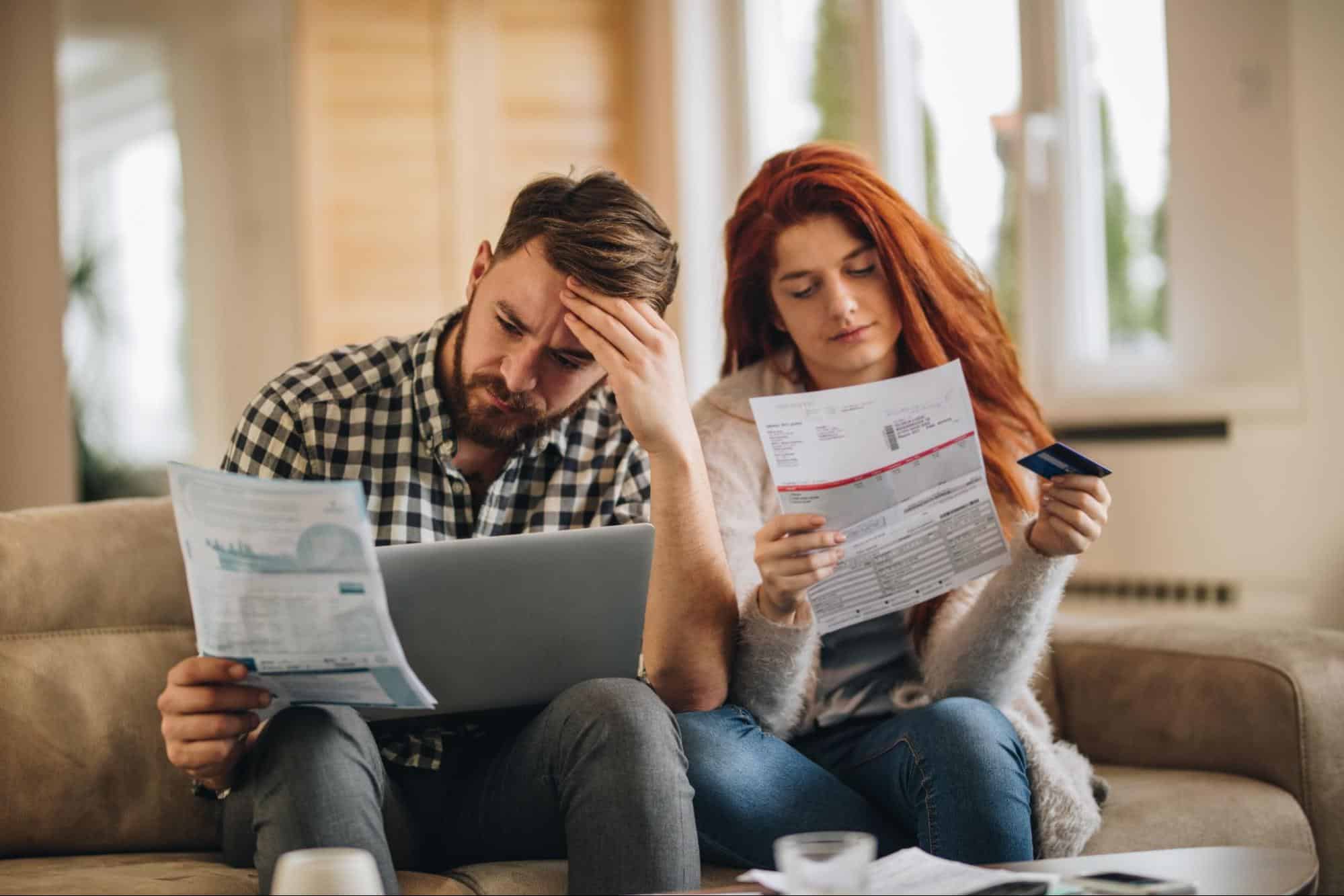 couple looking over past bills trying to figure out what kind of bankruptcy they should file