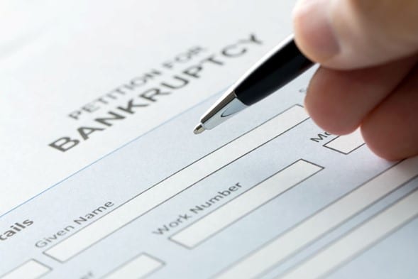 person filling out a petition for bankruptcy form